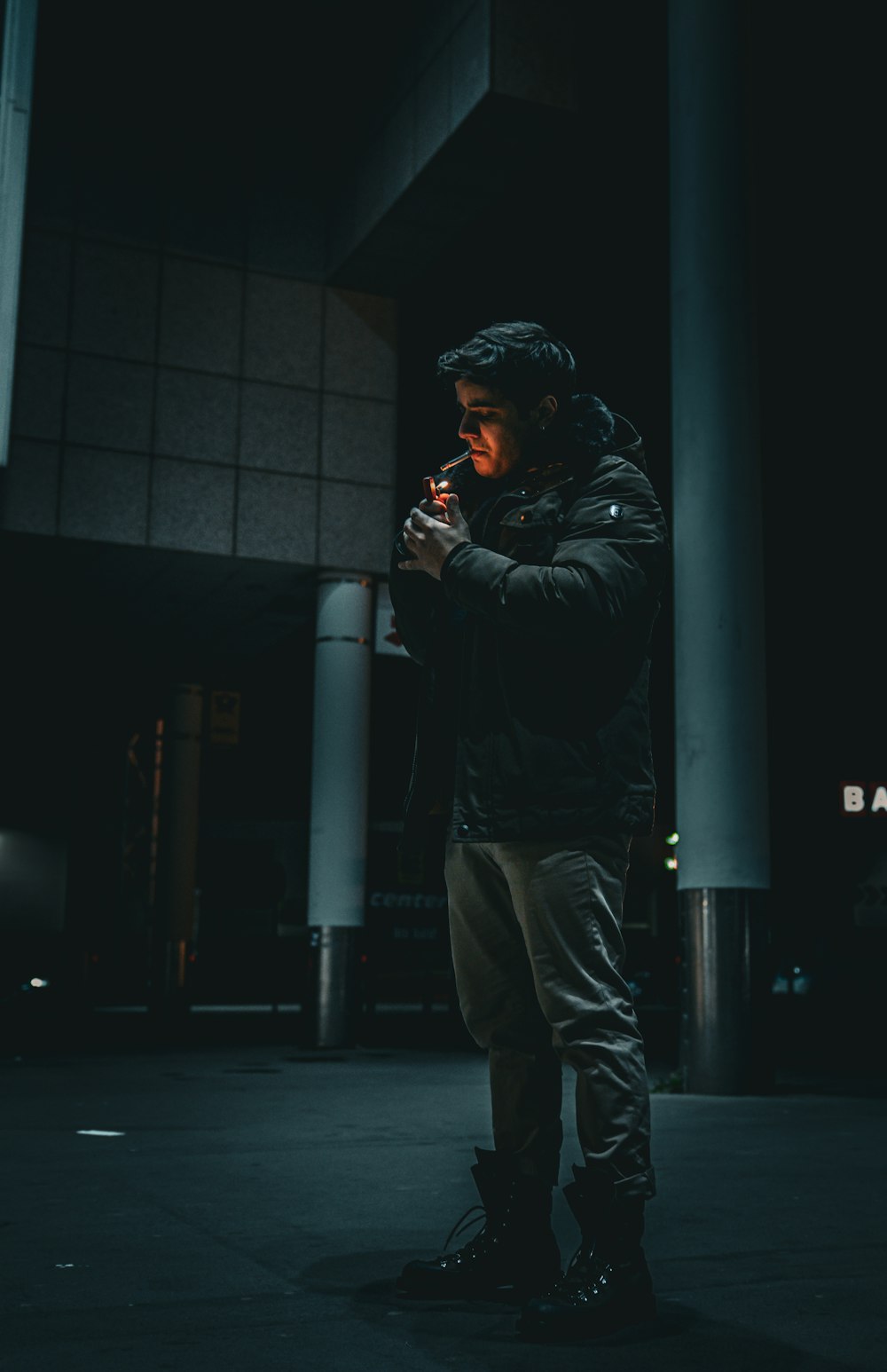 a man in a black jacket smoking a cigarette