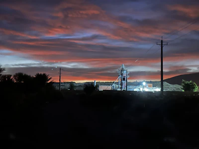 A warm sunset behind a group of retirees standing proudly in front of a historic power plant.