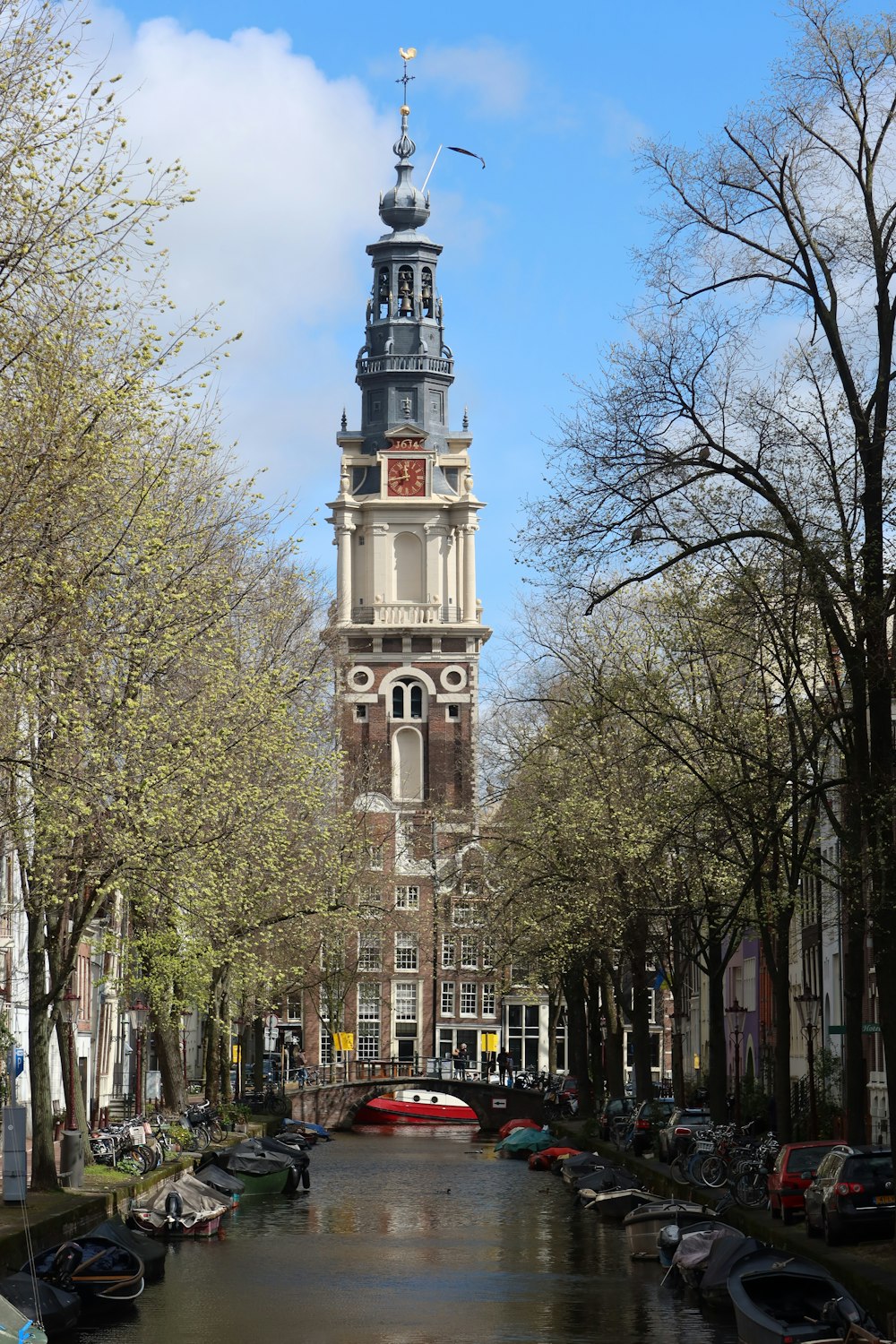 a tall building with a clock tower with Westerkerk in the background