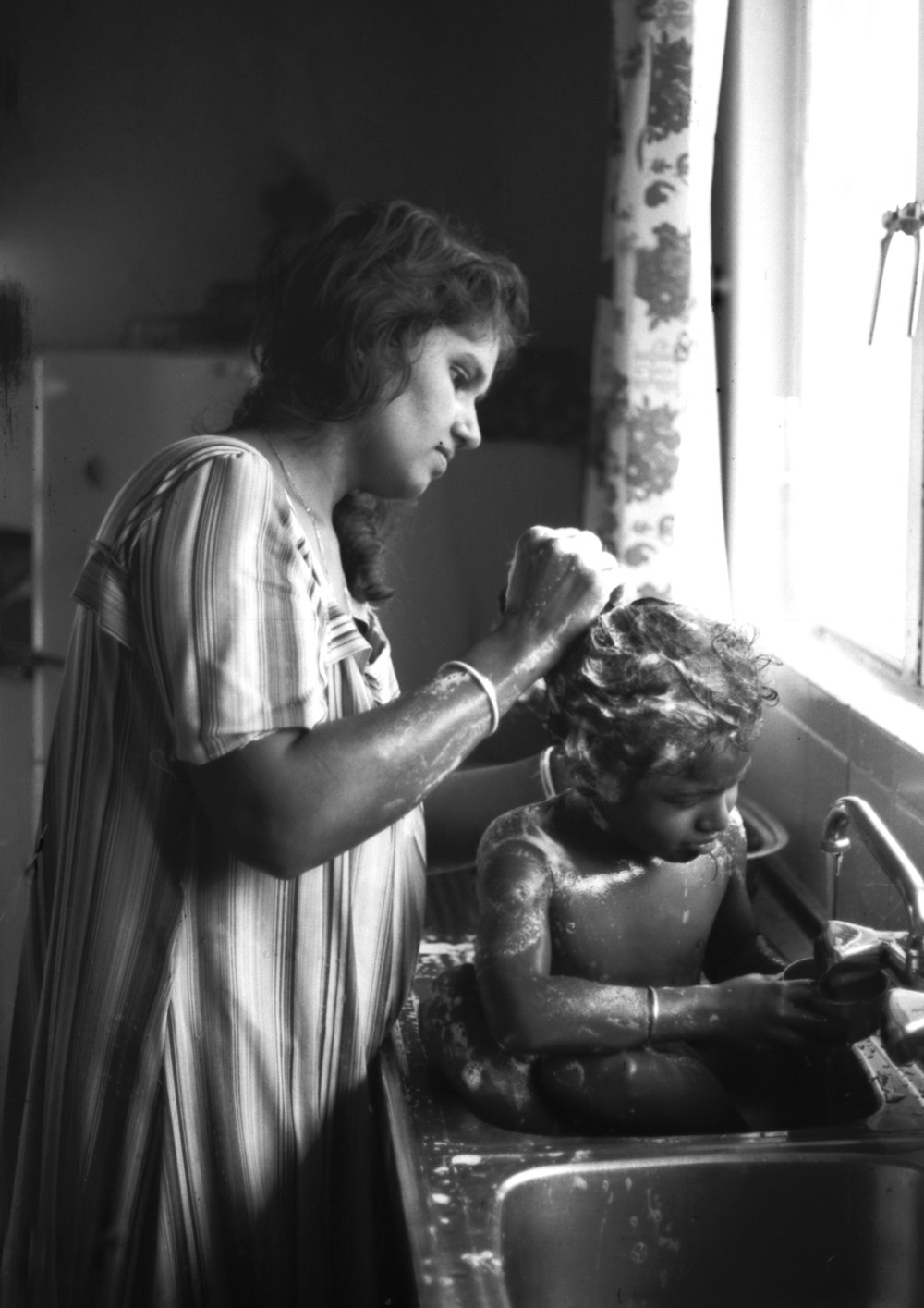 a person washing a child in a sink