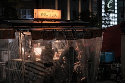 Cozy streetfood stall with warm golden lights and natural green leaf decorations.