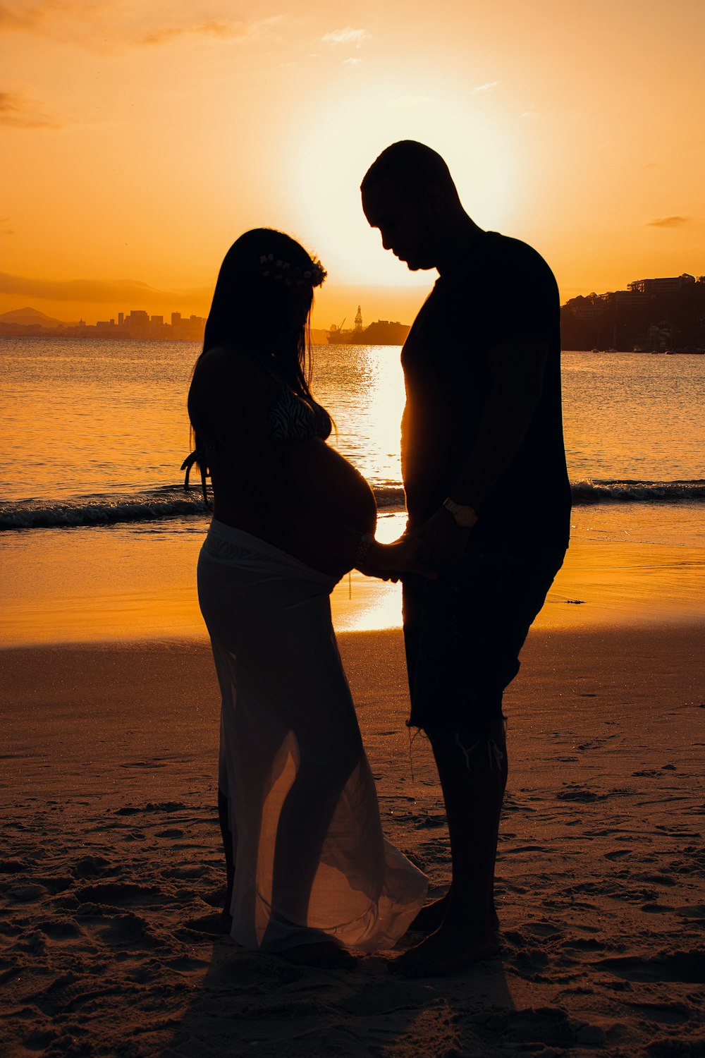 a man and woman kissing on a beach