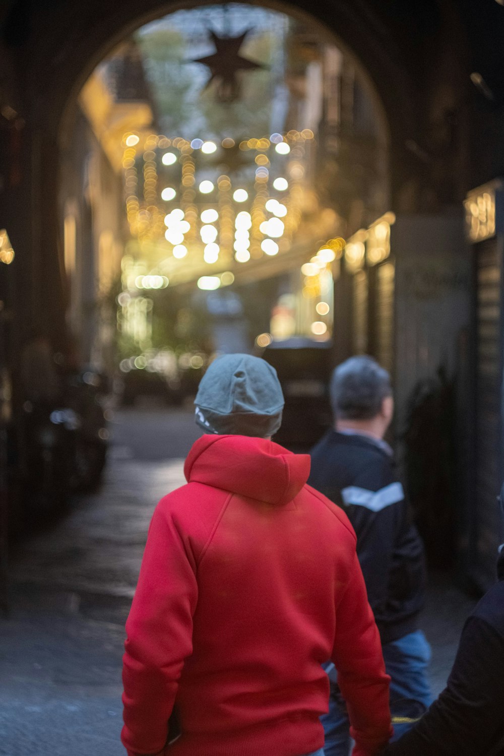 a group of people walking in a tunnel with lights