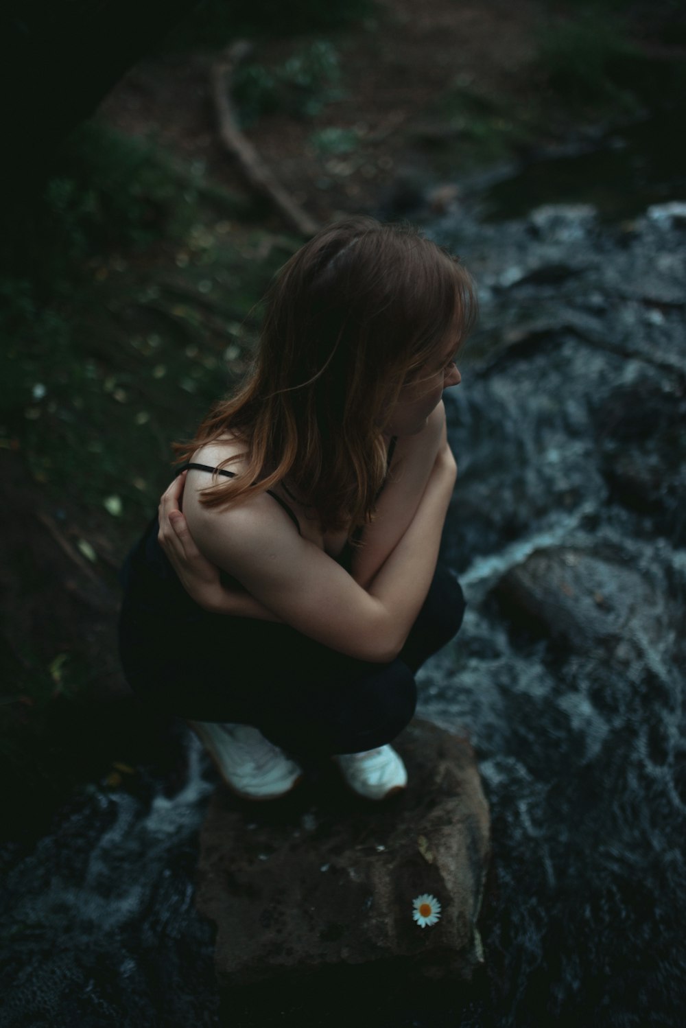 a girl sitting on a rock