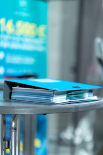 Carpeta corporativa azul con documentos sobre una mesa