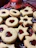 Artisan linzer cookies with jam centers arranged on a rustic wooden board.