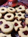 Artisan linzer cookies with jam centers arranged on a rustic wooden board.