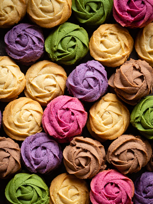 A beautifully arranged display of freshly baked cookies in soft pastel colors.