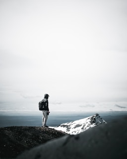 A lone traveler standing on a mountain ridge overlooking the sunrise in Himachal Pradesh.