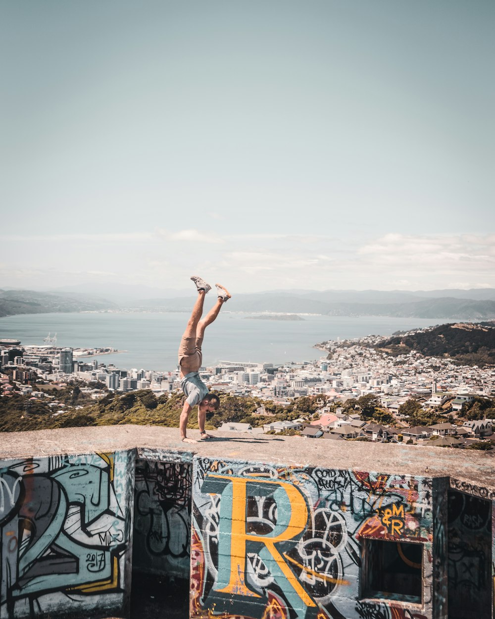 a man standing on a wall with a city in the background