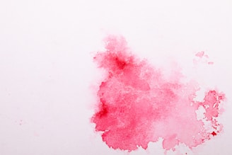 A soft pink watercolor splash behind a minimalist black cat silhouette.