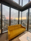 Modern suite featuring a stylish seating area and city skyline view at sunset.