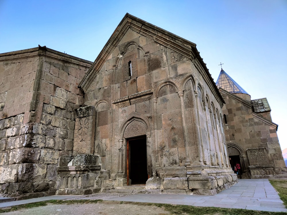 a stone building with a cross on top with San Simplicio, Olbia in the background