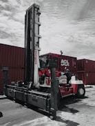 Workers securing heavy equipment inside a shipping container