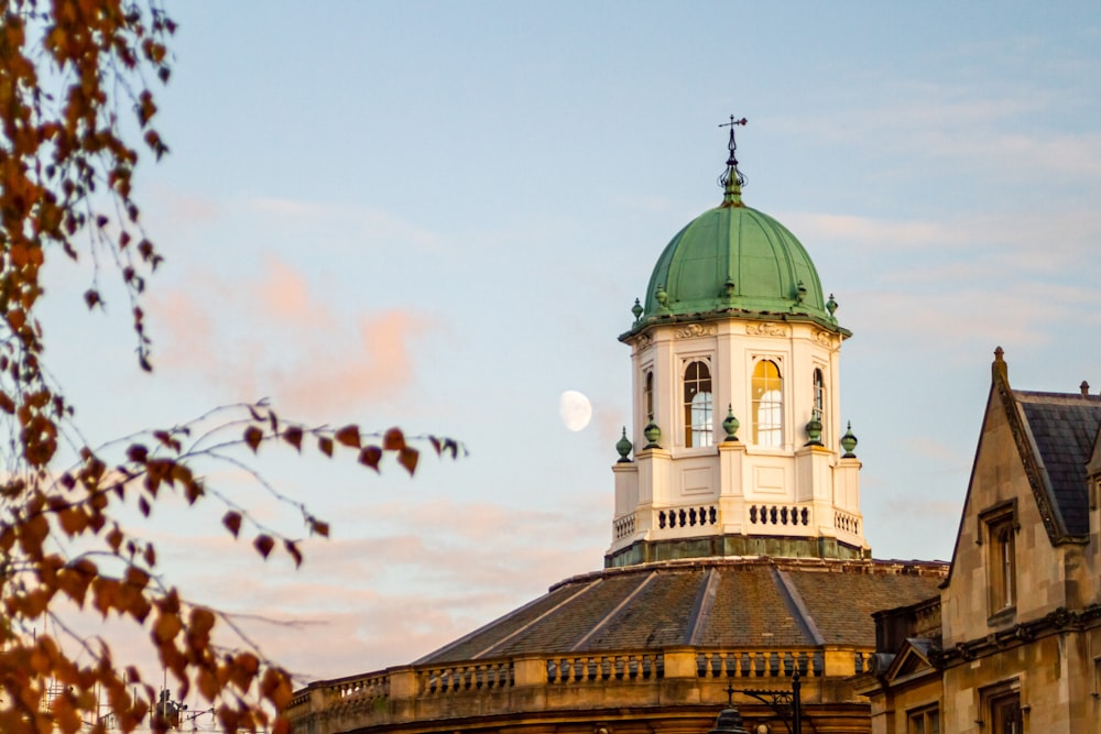 a building with a green dome and a cross on top