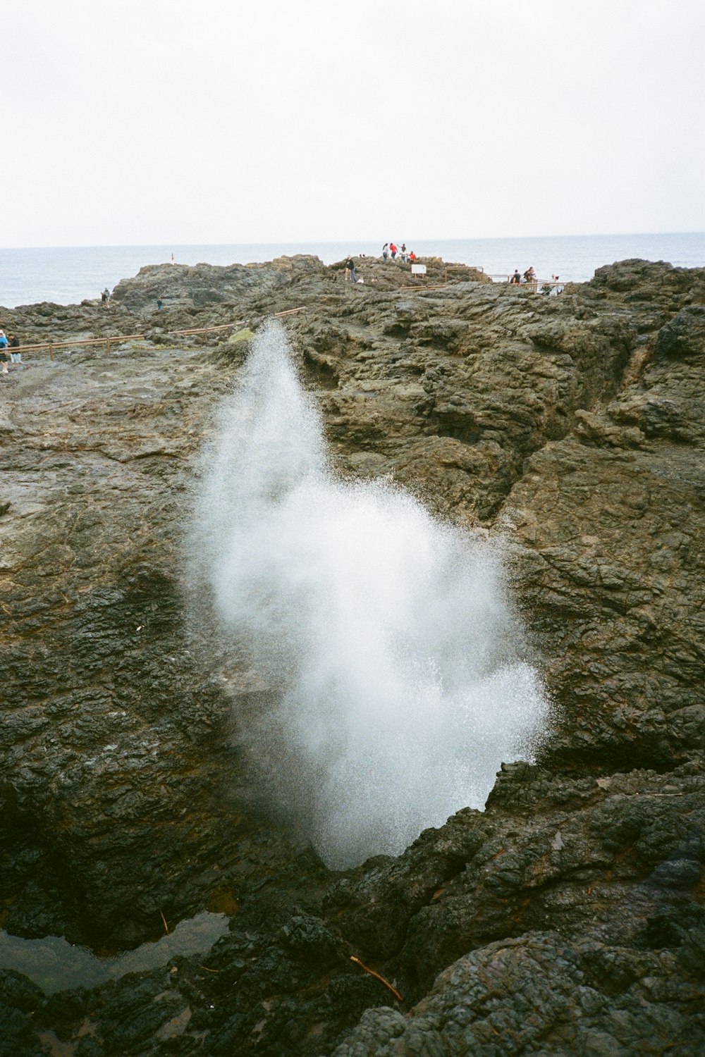 a waterfall with people standing on the side