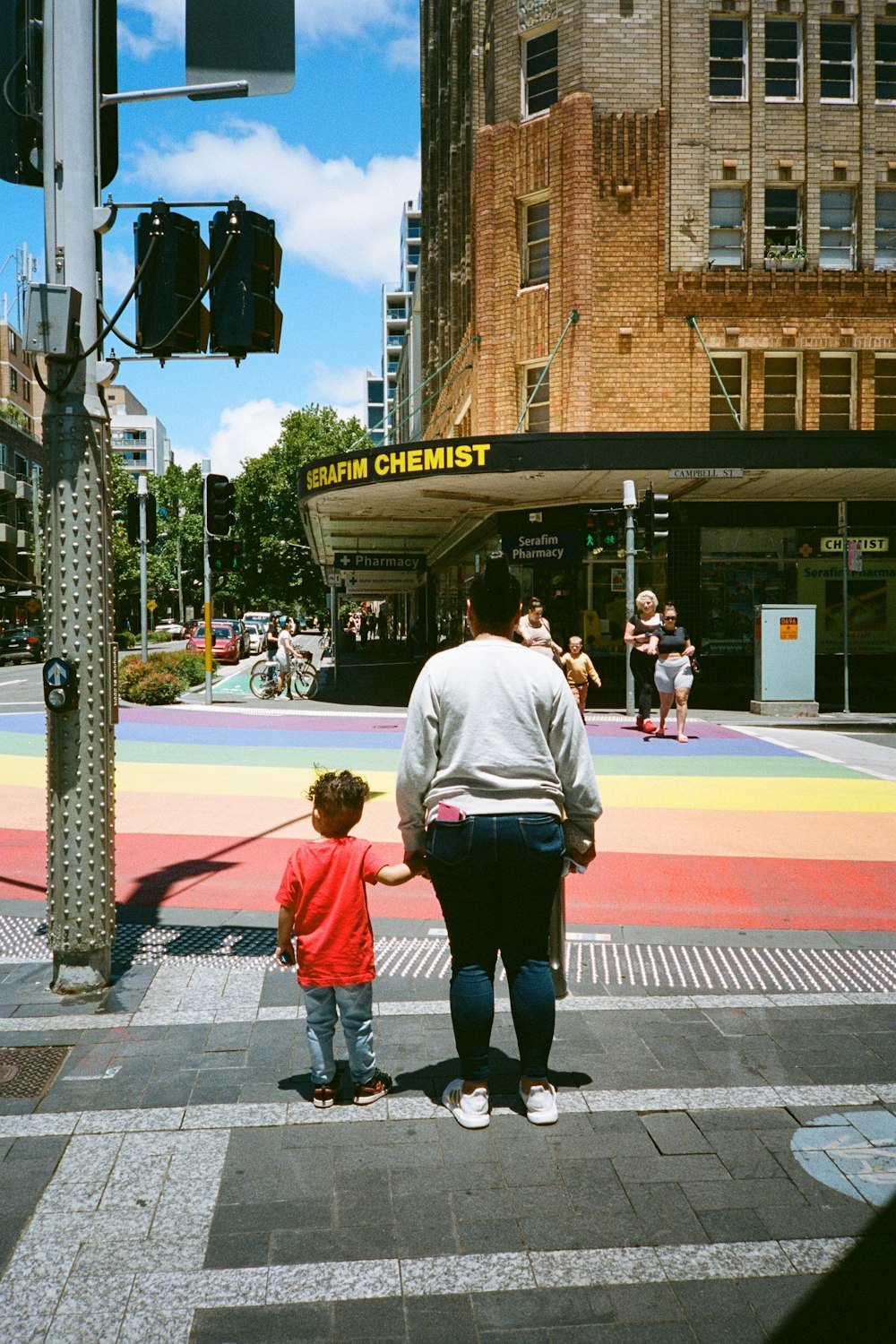 a person and a child walking on a crosswalk