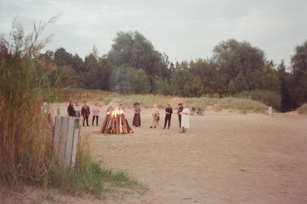 a group of people standing on a dirt road with a group of people around