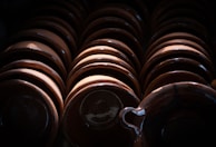 Overhead shot of a series of small ceramic bowls in soft earth tones arranged on a wooden table.