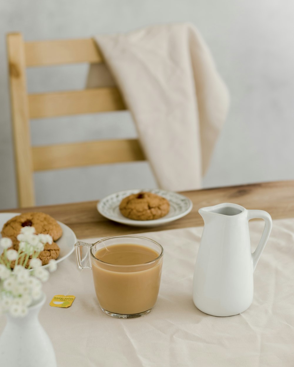 a table with plates of food and a pitcher of tea