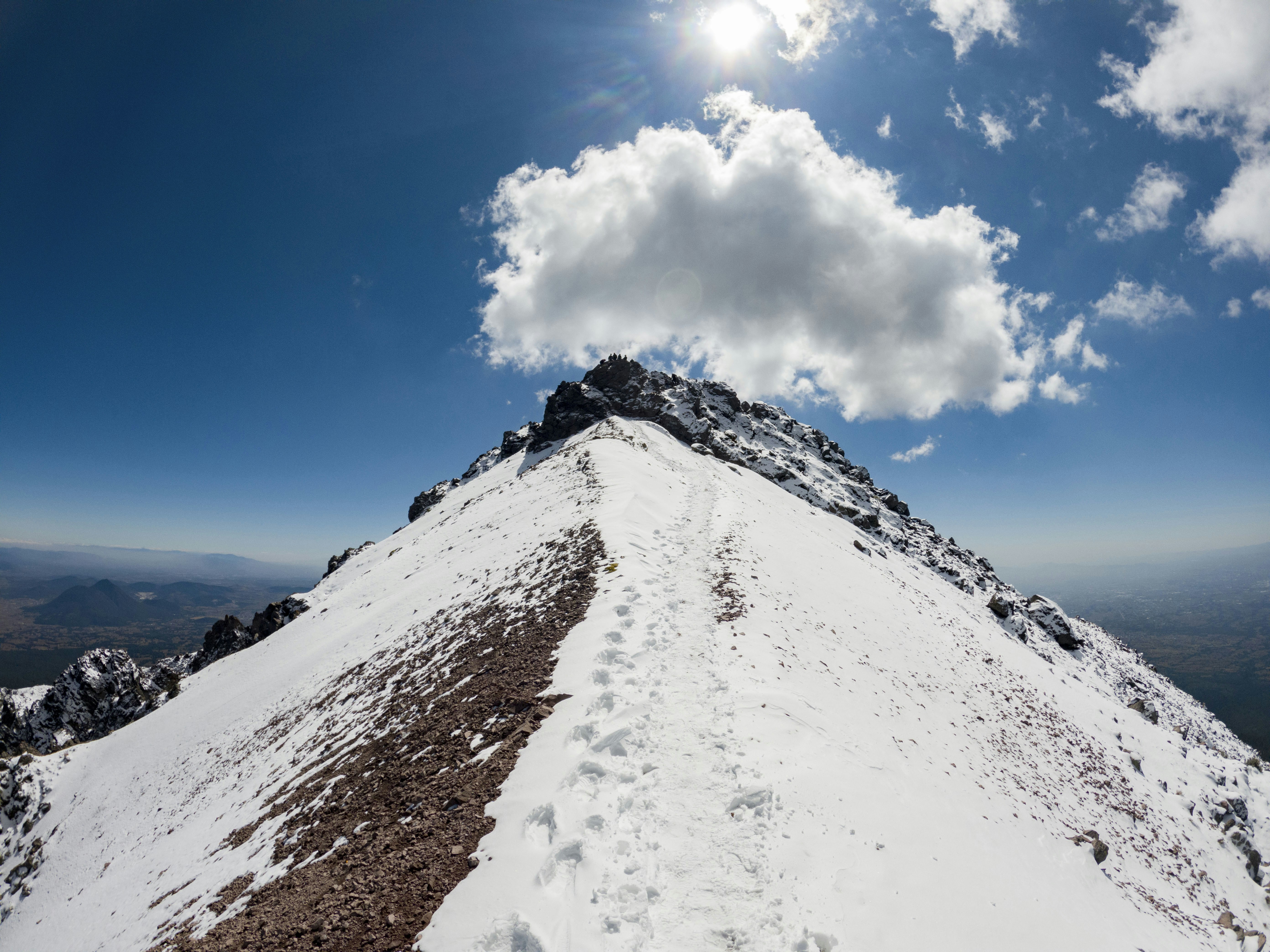 a snowy mountain with clouds