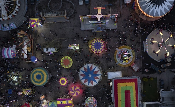 A scenic view of festival rides and games bustling with activity.