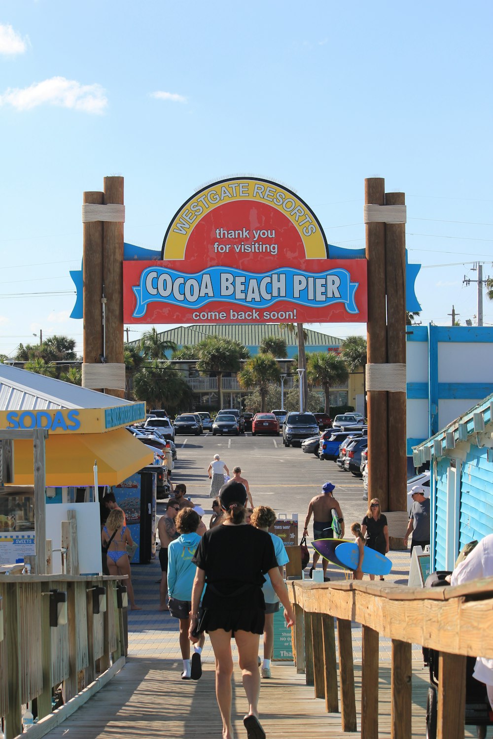 a group of people walking on a boardwalk