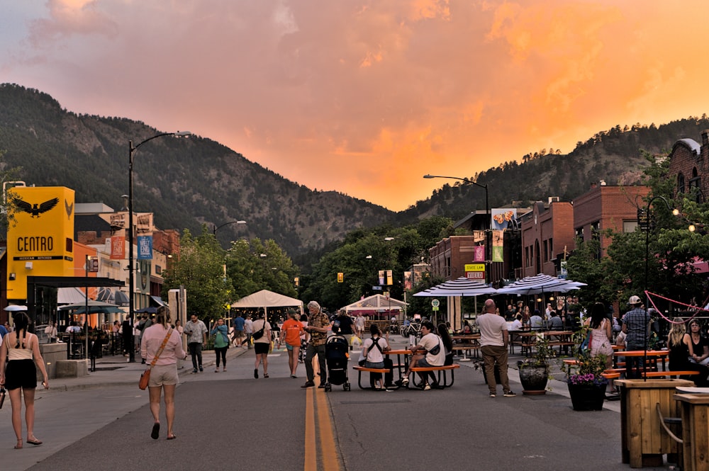 a group of people walking on a street with mountains in the background