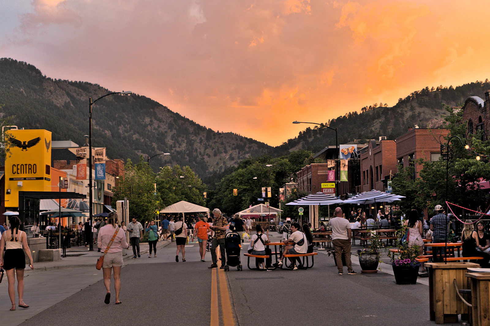 Pearl Street in downtown Boulder, Colorado at sunset with the foothills behind