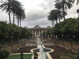 A tranquil garden pathway winding through a historic hotel property with flowering plants.