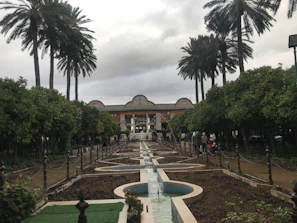 A tranquil garden pathway winding through a historic hotel property with flowering plants.