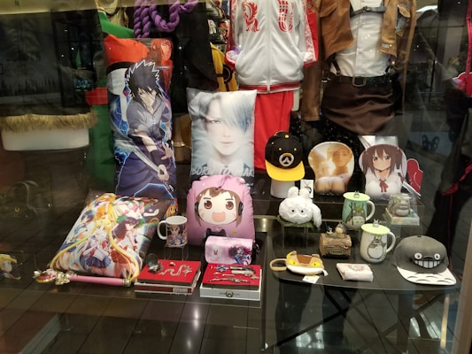Assorted gaming merchandise like t-shirts, caps, and collectible figures featuring popular game characters.