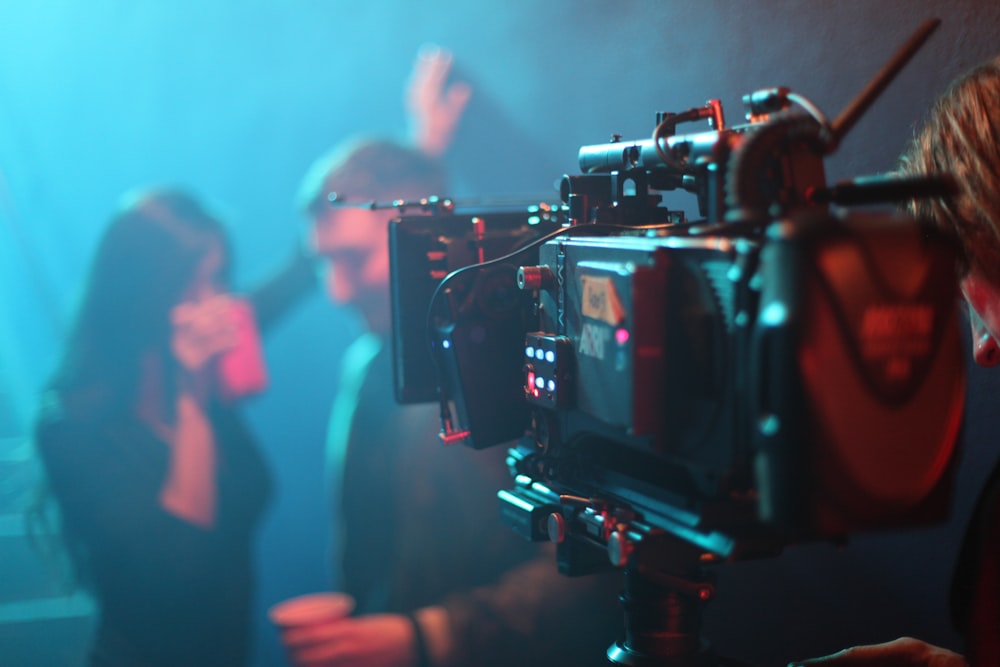 a group of people in a room with a camera and a man with a camera