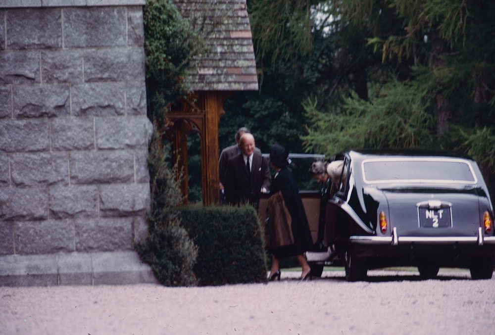 a man and woman in robes standing outside a house