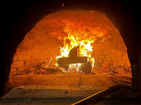 A cozy wood-fired oven glowing warmly inside La Flamm’s kitchen.