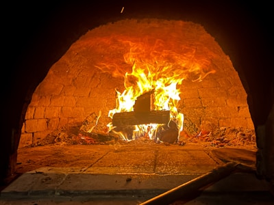 A cozy wood-fired oven glowing warmly inside Chez Mimi's kitchen.