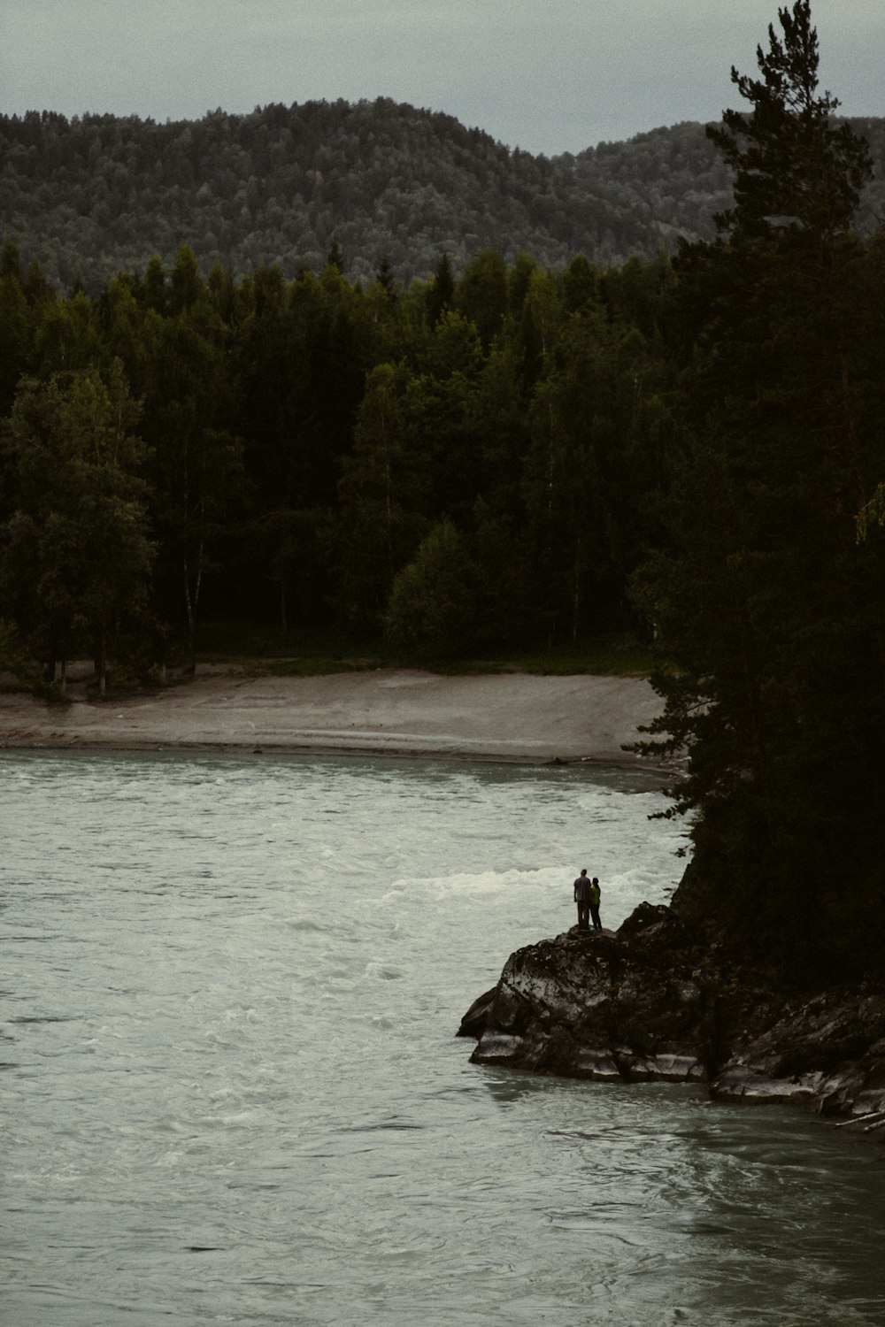 Una persona parada en una roca en un lago