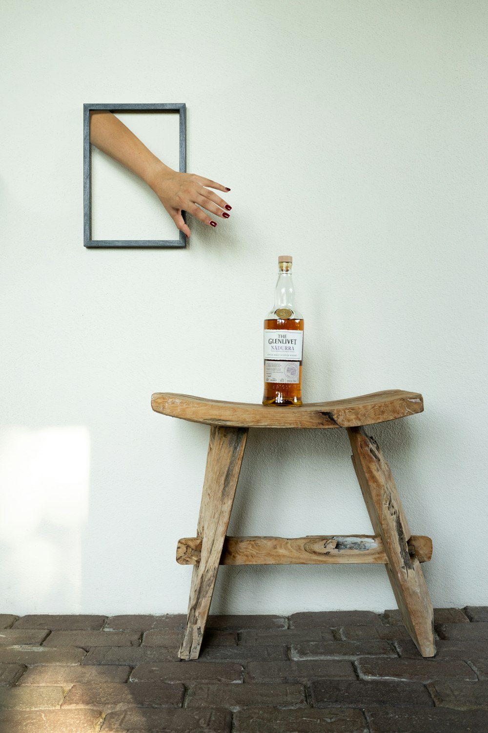 a bottle of alcohol on a wooden bench