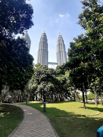 A stunning view of the twin towers of Discovery Park Phase 2 rising above a vibrant vertical garden under a clear blue sky.