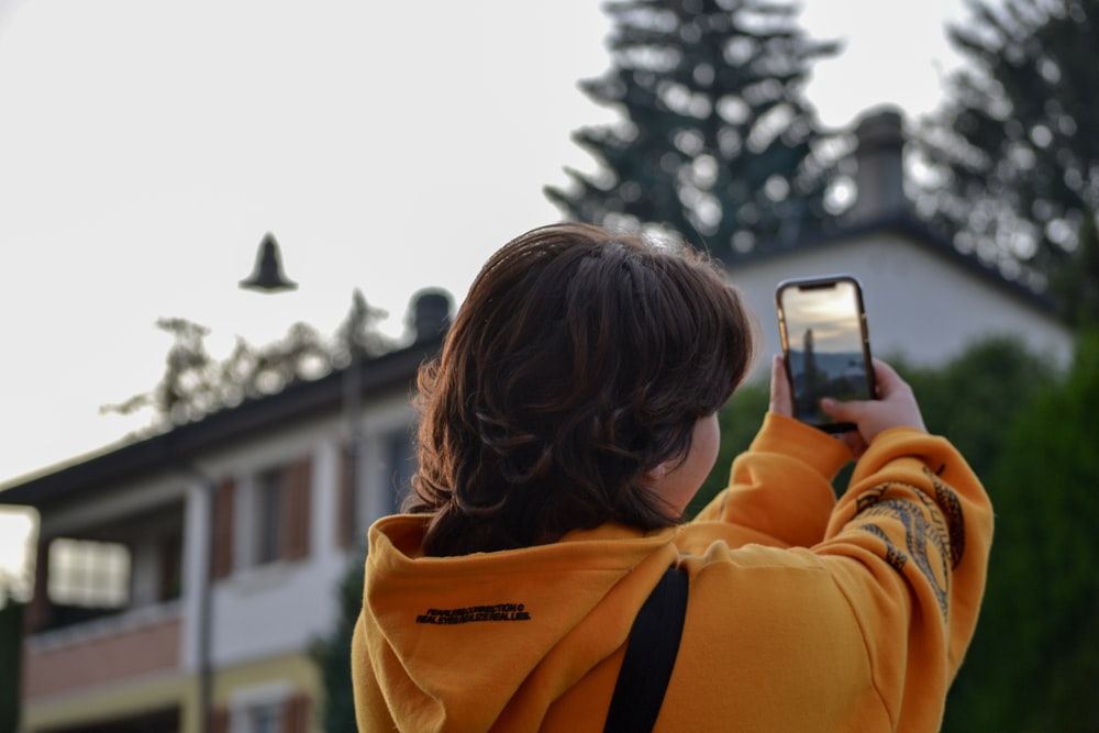 a woman taking a picture of a house