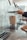 Close-up of hands using a sleek home appliance on a kitchen countertop.