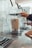 Close-up of hands using a sleek home appliance on a kitchen countertop.