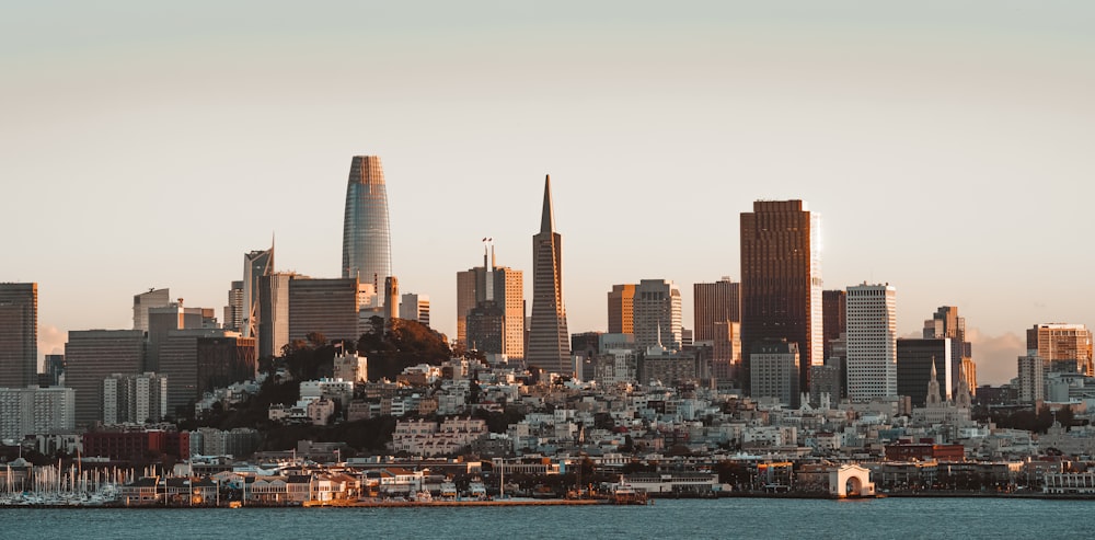 a city skyline with a body of water in the foreground