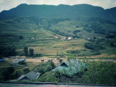 A serene river winding through terraced rice fields with local villagers working peacefully.