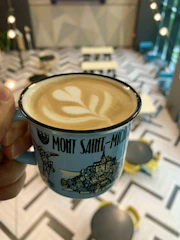 Close-up of a hand holding a coffee mug with a Breton joke printed.