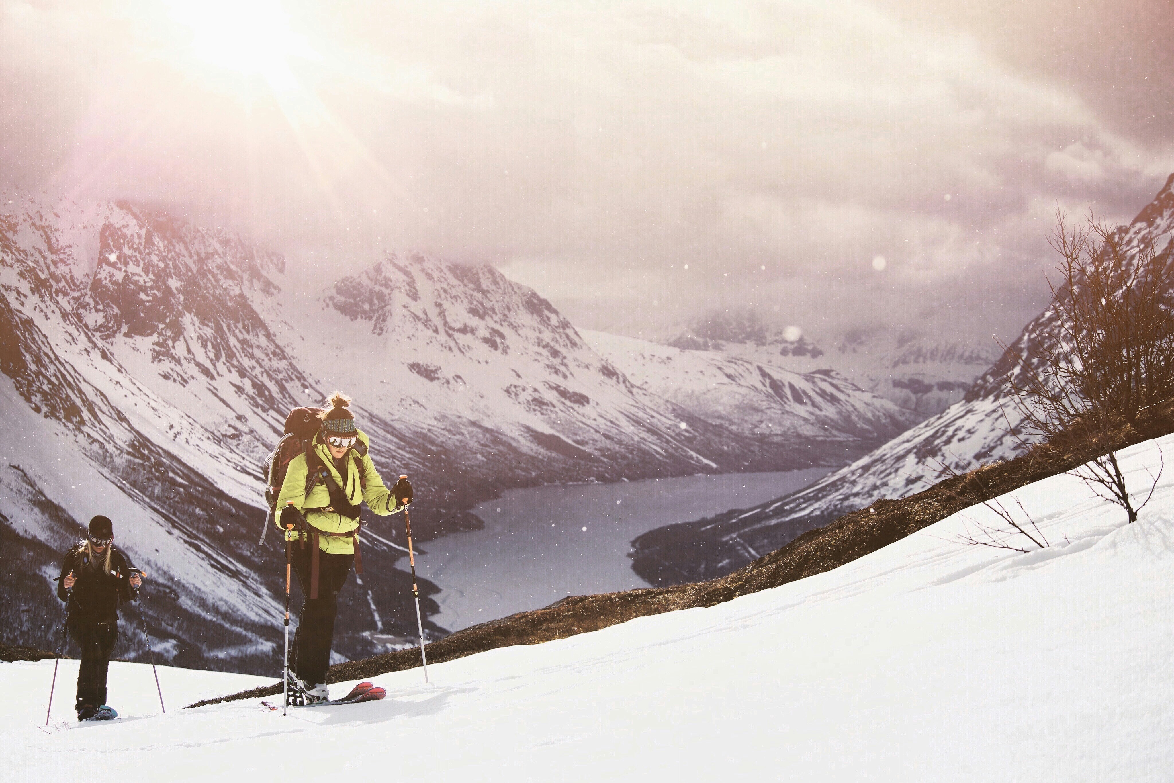 a couple of people stand on snow skis