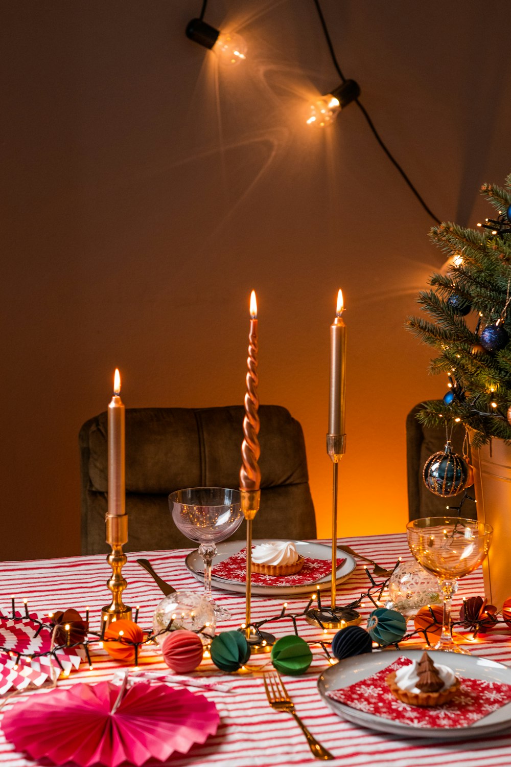 a table with plates and glasses with candles on it