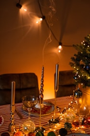 A cheerful holiday party setup with elegant table decorations, glowing candles, and sparkling ornaments.