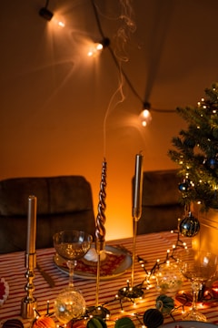 A festive table setup with DIY paper garlands, elegant tableware, and softly glowing string lights.