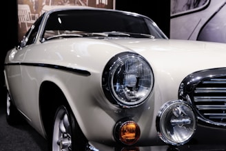 A polished vintage car shining under showroom lights at Khan Motors.